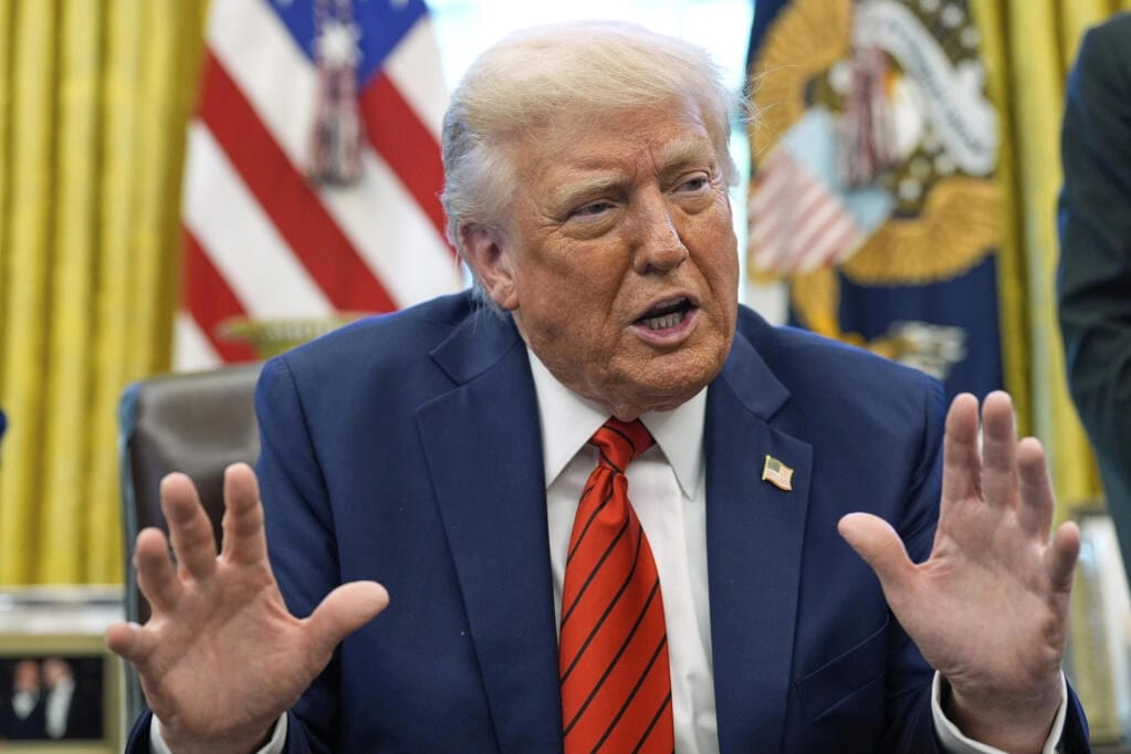 President Trump signing an executive order restricting F1 visas for Harvard students while White House officials look on.